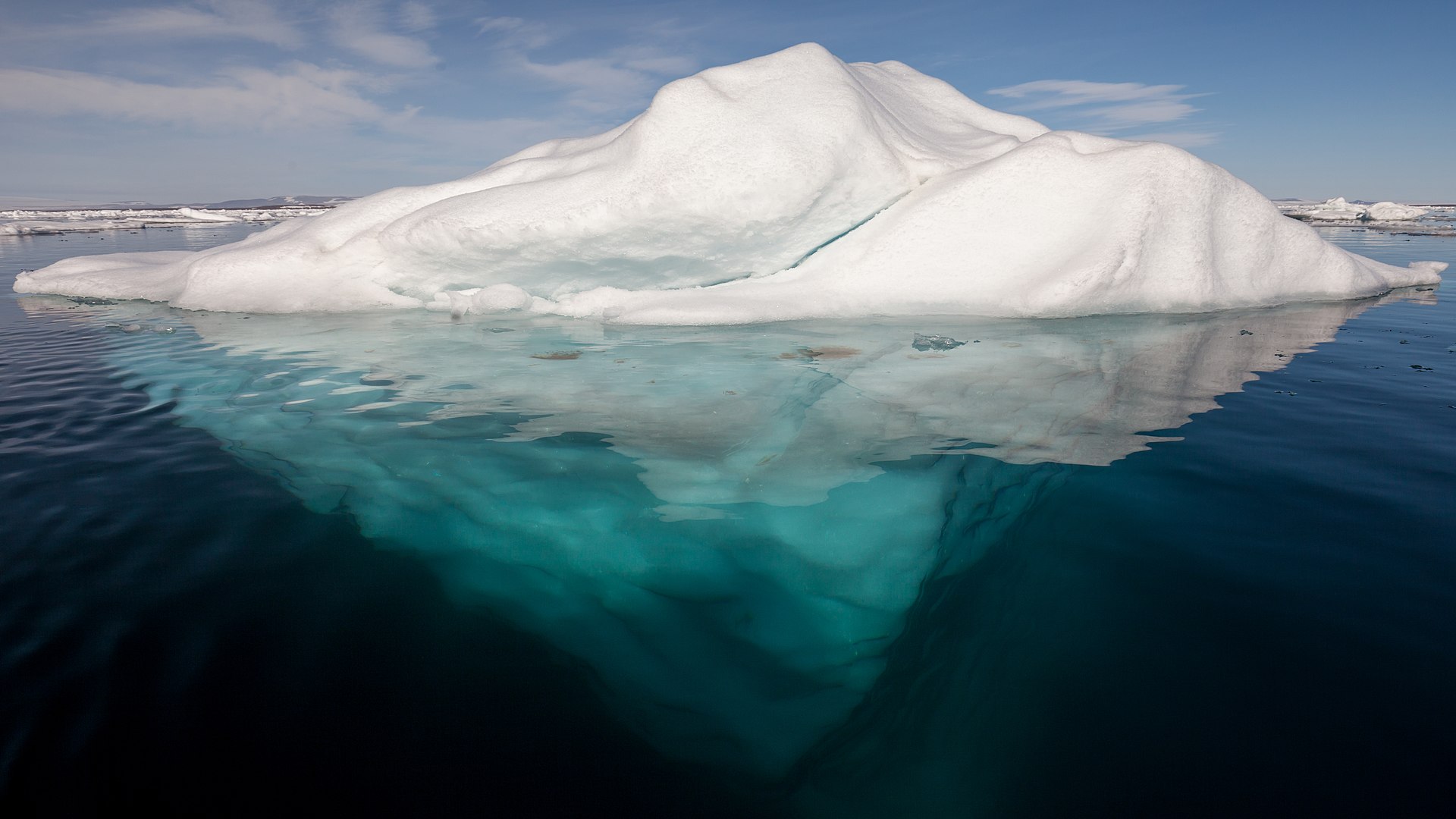 An iceburg floating with more ice below water than above