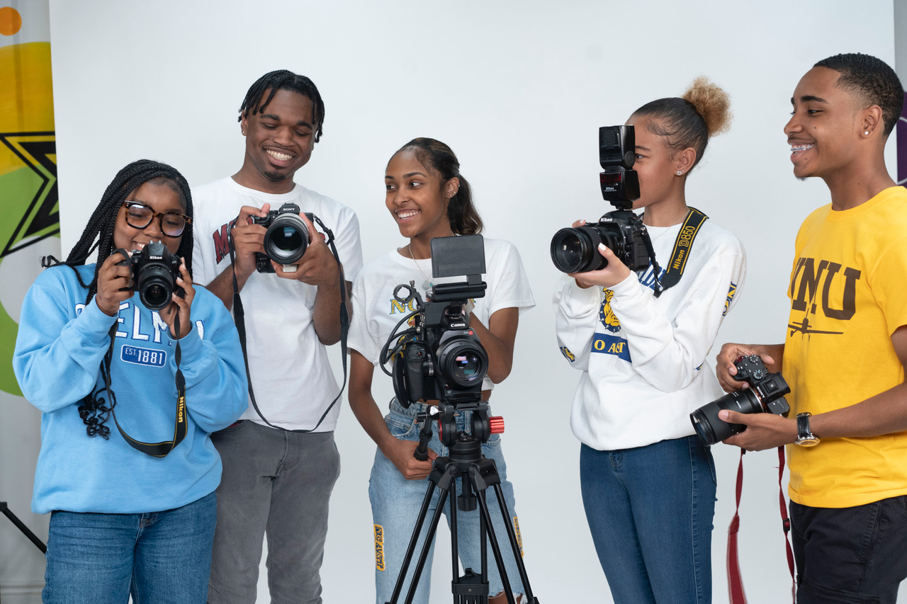 youth holding video cameras in a studio.