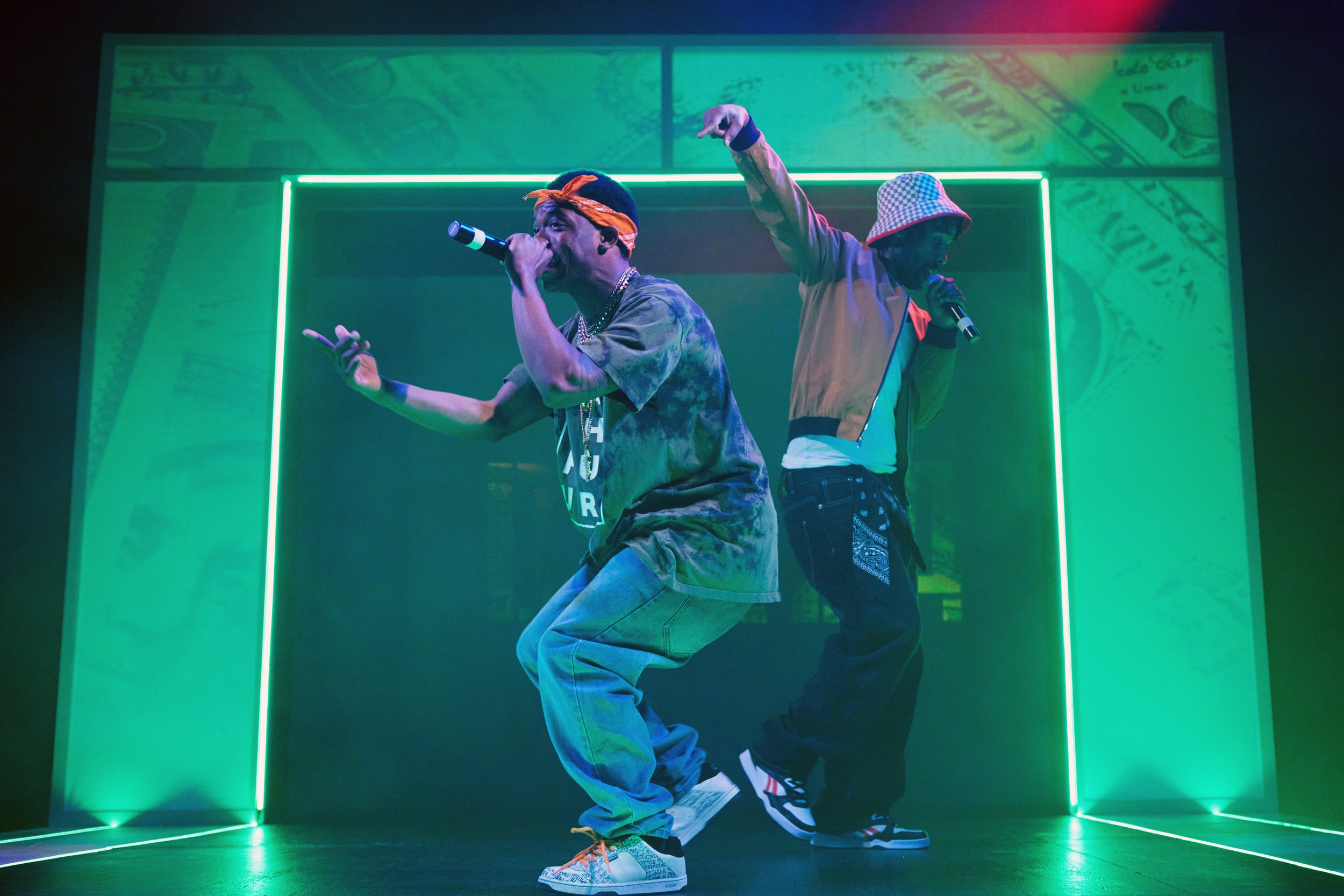 Two Black men on stage with microphones