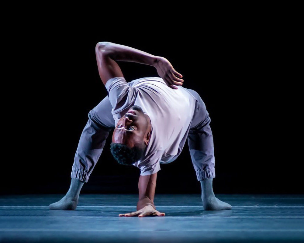 A dancer twisting their body upside down