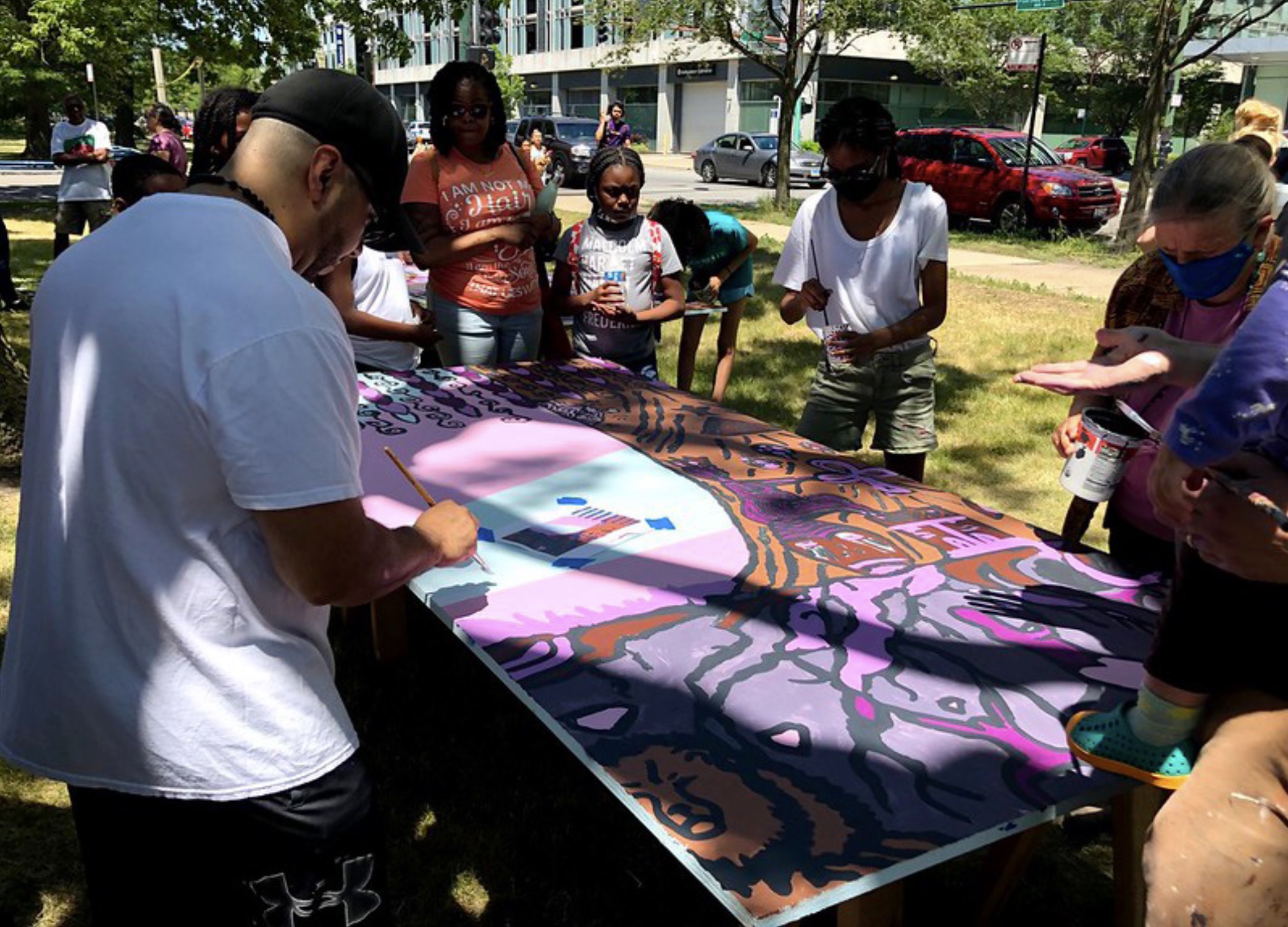 A teaching artist working with students in a park